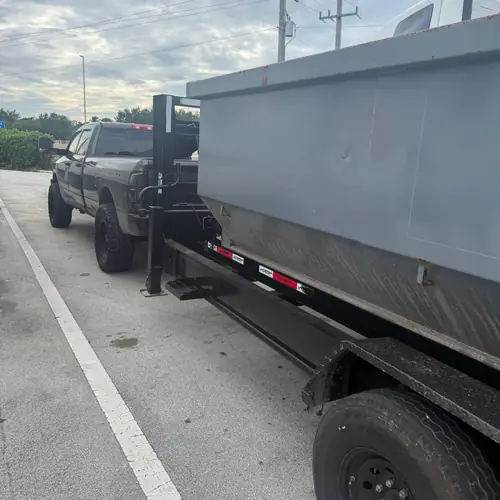 Dump trailer hitched to pickup truck for business junk hauling in Broward County