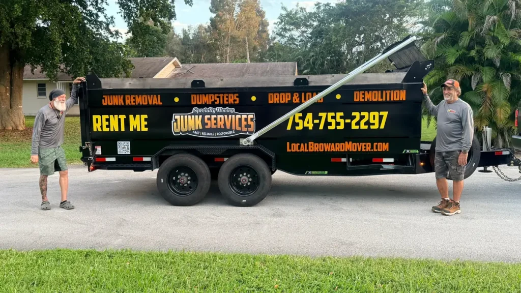 Junk removal crew beside branded dump trailer after a cleanup in South Florida